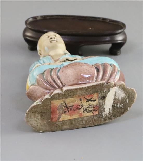 A Chinese enamelled biscuit seated figure of Buddha, 18th/19th century, H. 9.5cm, wood stand